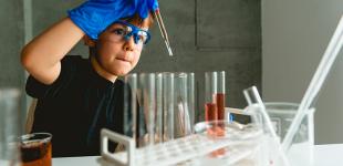 Niño realizando un experimento con tubos de ensayo
