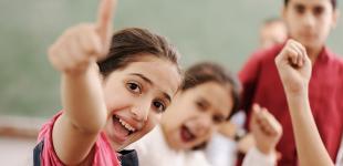 niños sonriendo y levantando el dedo meñique