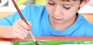 La imagen muestra a un niño pequeño realizando una actividad artística