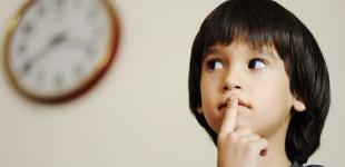 La imagen muestra a un niño con el dedo sobre la boca y los ojos mirando hacia el lado, pensando en algo