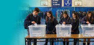 Grupo de estudiantes participando en una votación escolar.