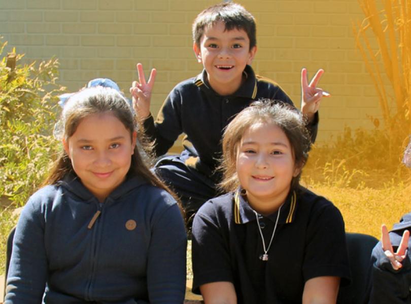 Niños y niñas saludando en un día soleado