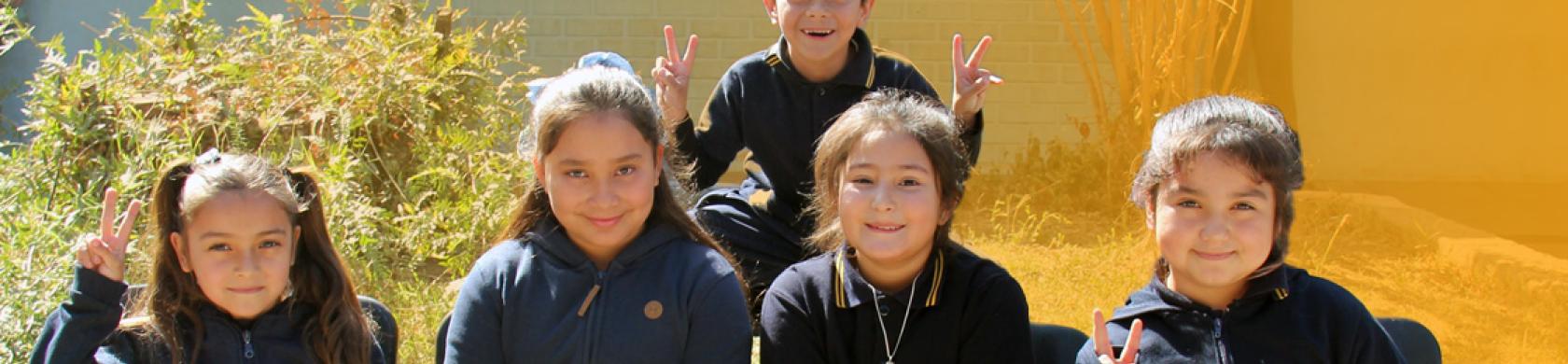 Niños y niñas saludando en un día soleado