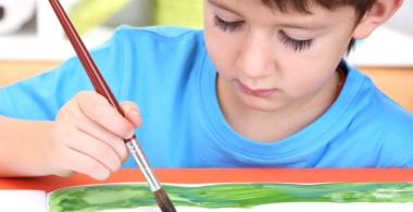Se obaserva a un niño pintando con distintos colores