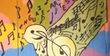 Imagen de puerta pintada con una pájaro que tiene dibujado notas musicales.
