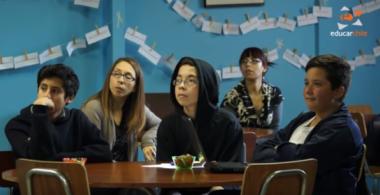 Imagen de niños y docentes sentados en sala de clases