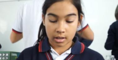 niña tejiendo una cartera con materiales reciclados
