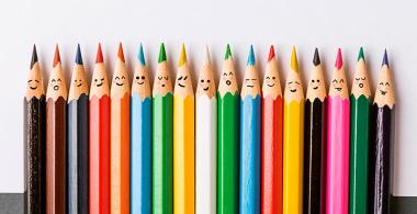 Fotografía de lápices de distintos colores con diversas expresiones de emociones.