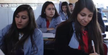 La imagen muestra a 2 alumnas tomando apuntes