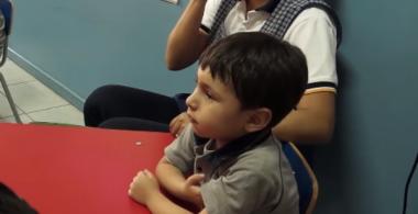 esta imagen muestra un niño de kinder poniendo atención en clases