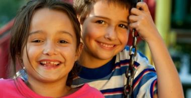 Imagen que muestra a un niño y niña de educación parvularia en un columpio