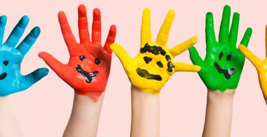Fotografía de varias manos infantiles pintadas de colores