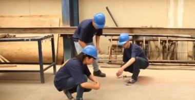 La imagen muestra a tres estudiantes de construcción realizando mediciones para construir una cercha