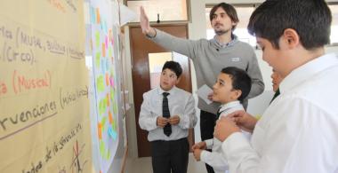 profesor con estudiantes frente a un pizarrón
