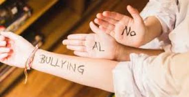 Manos y brazo escrito con "no más bullying"