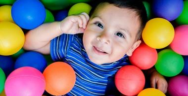 Niño de 2 años en una piscina de pelotas de colores