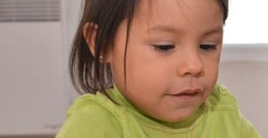 La imagen muestra a un niño pequeño con un juego didáctico en sus manos