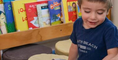La imagen muestra a un niño pequeño que sigue una lectura 