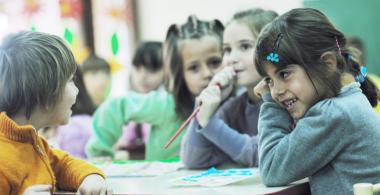 La imagen muestra estudiantes trabajando en grupos
