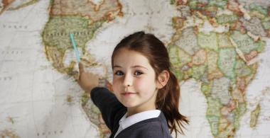La imagen muestra a una niña apuntando un mapa 