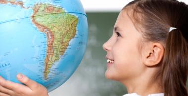 La imagen muestra a una niña observando un globo terraqueo