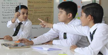 La imagen muestra 3 niños compartiendo ideas