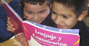 La imagen muestra a 2 niños leyendo el libro de lenguaje y comunicación