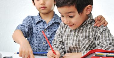 La imagen muestra a dos niños realizando actividades con útiles