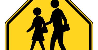señal de transito amarilla de escuela con dos escolares