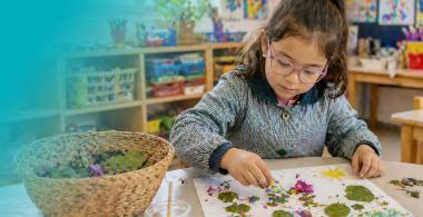 Niña realizando manualidades en sala de clases.